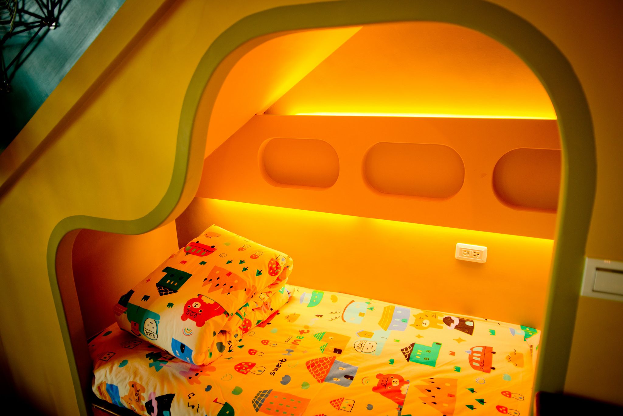A child's bed with a colorful, playful design and a built-in reading light.