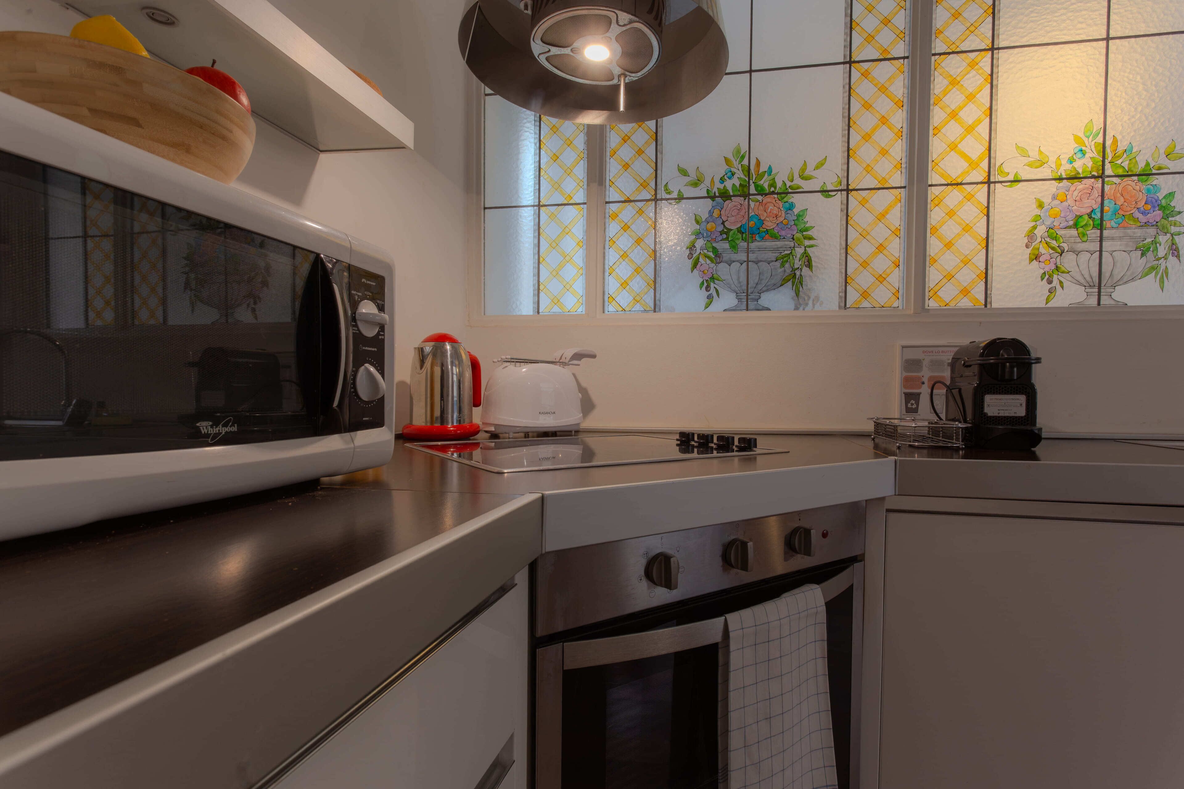 A modern kitchen with a microwave, kettle, and coffee maker.