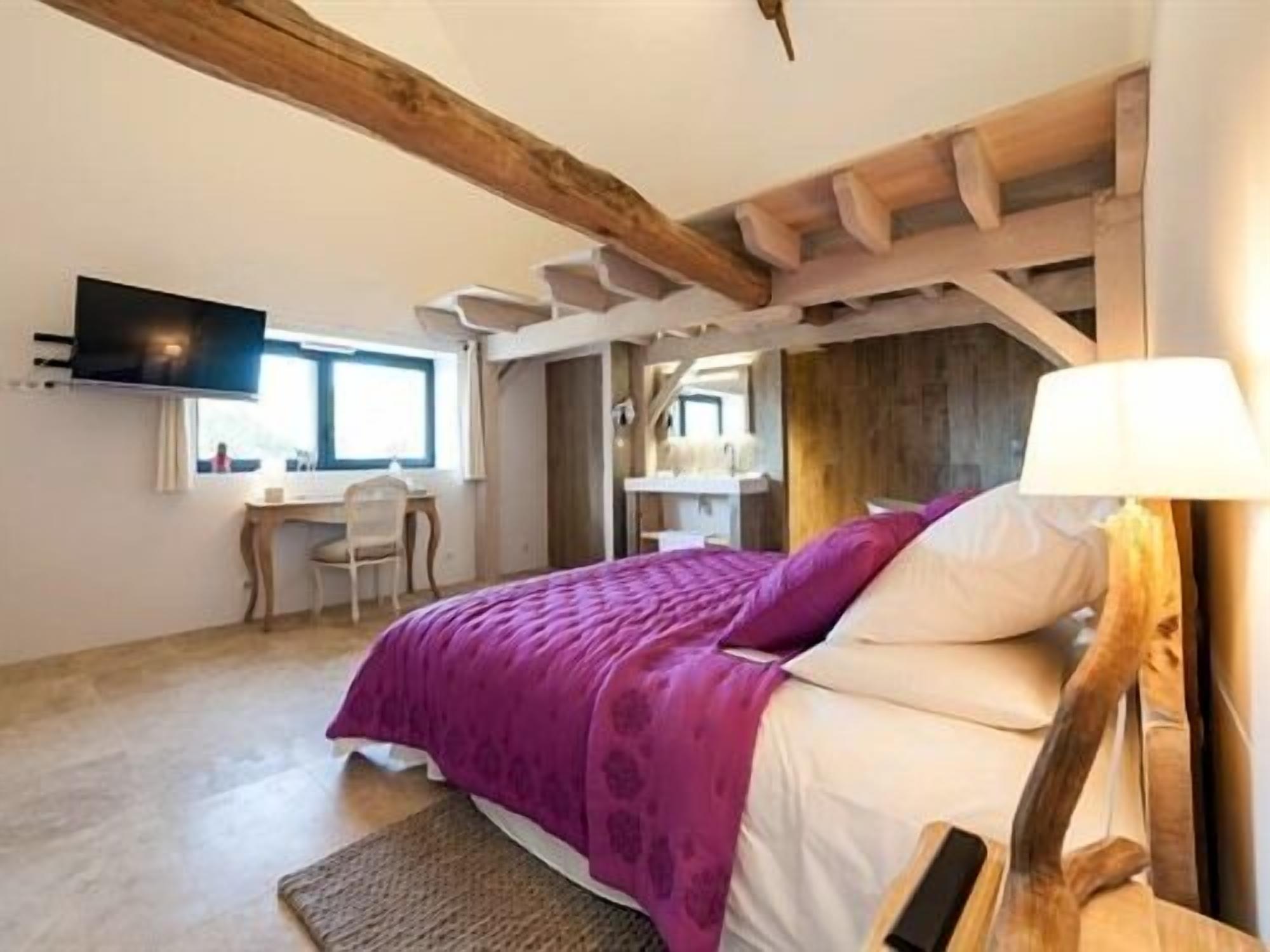 Un dormitorio con cama, escritorio y televisor.