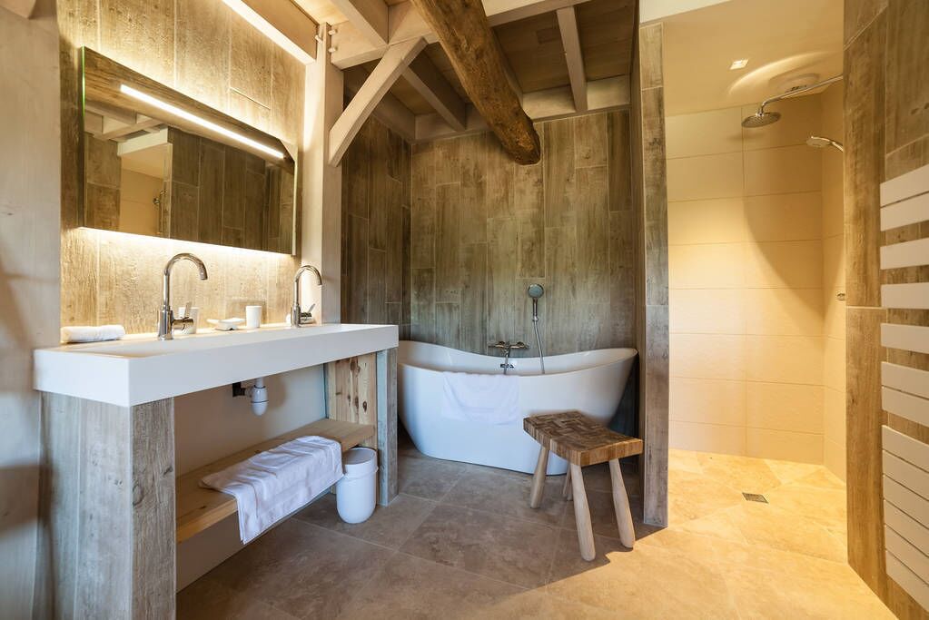 Ein modernes Badezimmer mit einem Holz-Waschtisch, einer freistehenden Badewanne und einer Duschkabine.