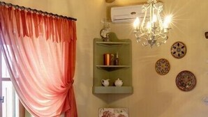 Een eetruimte met een houten plafond, een kroonluchter, een tafel gedekt voor vier personen en een raam met gordijnen.