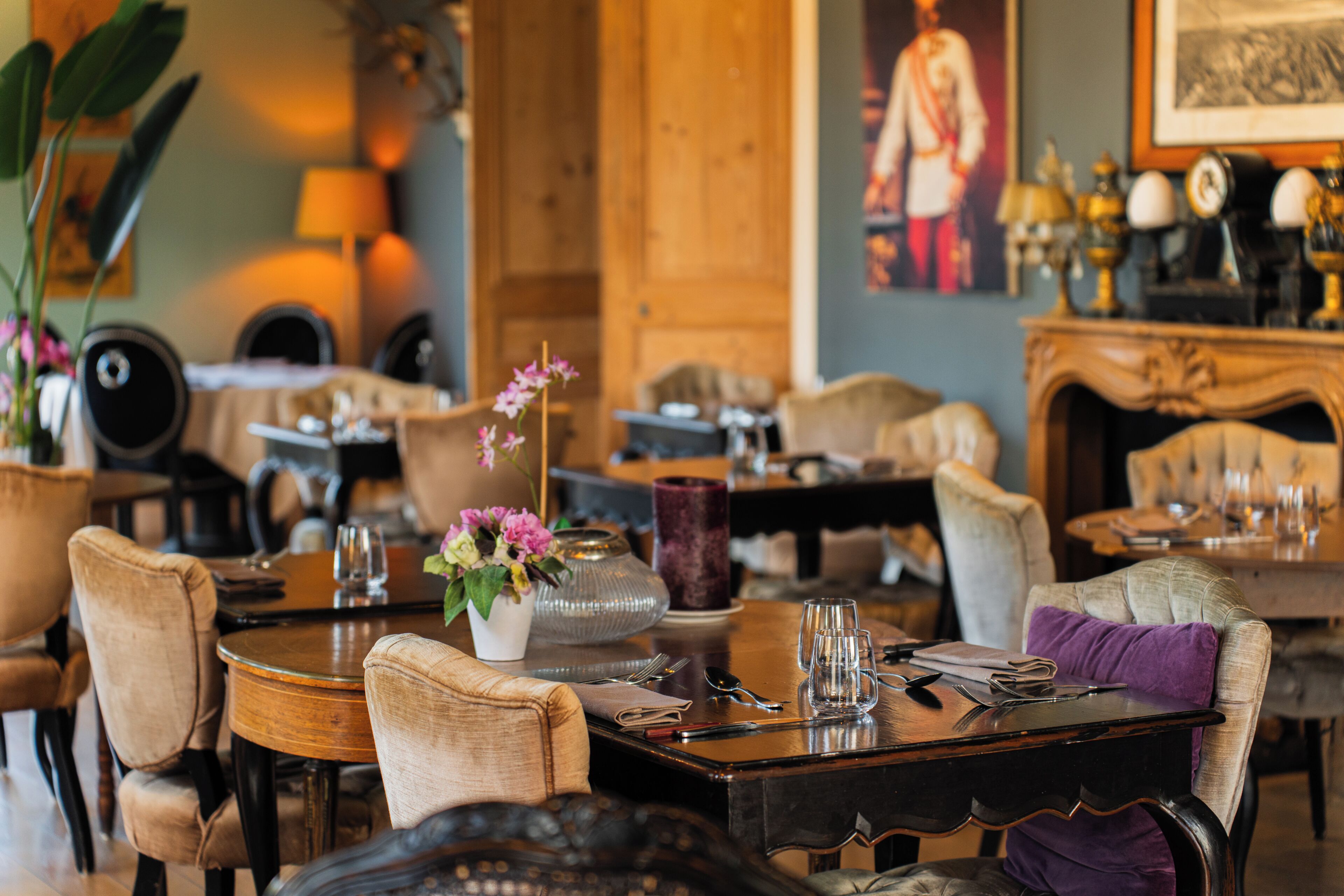 Un espace repas avec des tables rondes, des chaises et un vase rempli de fleurs.