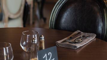 A dining table with a number sign, glasses, and cutlery.