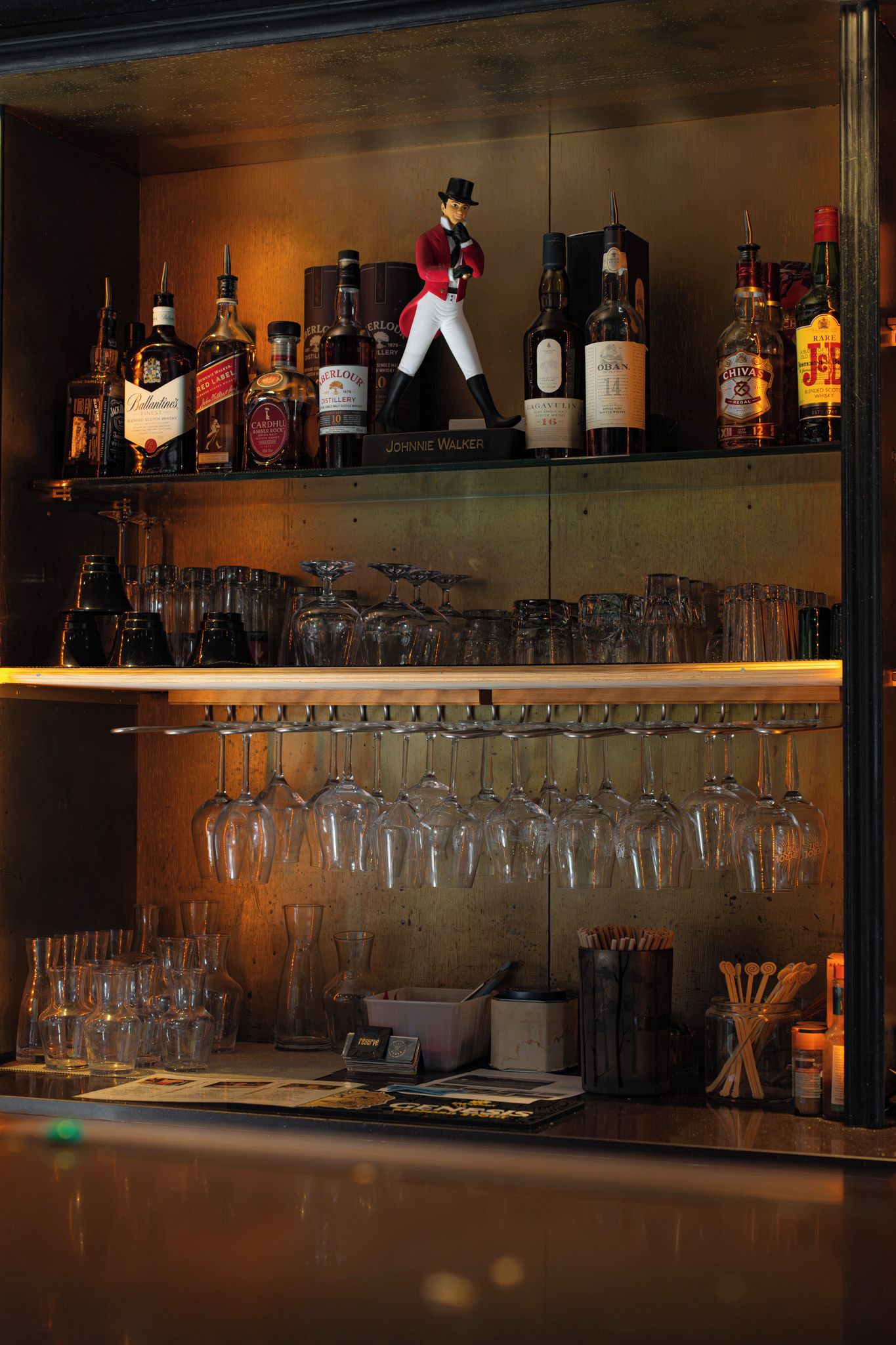 A bar with shelves of liquor bottles and a figure of a man.