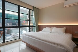 A hotel room with a large bed, a view of the street, and a modern design. - Green Hotel Puchong (Puchong)
