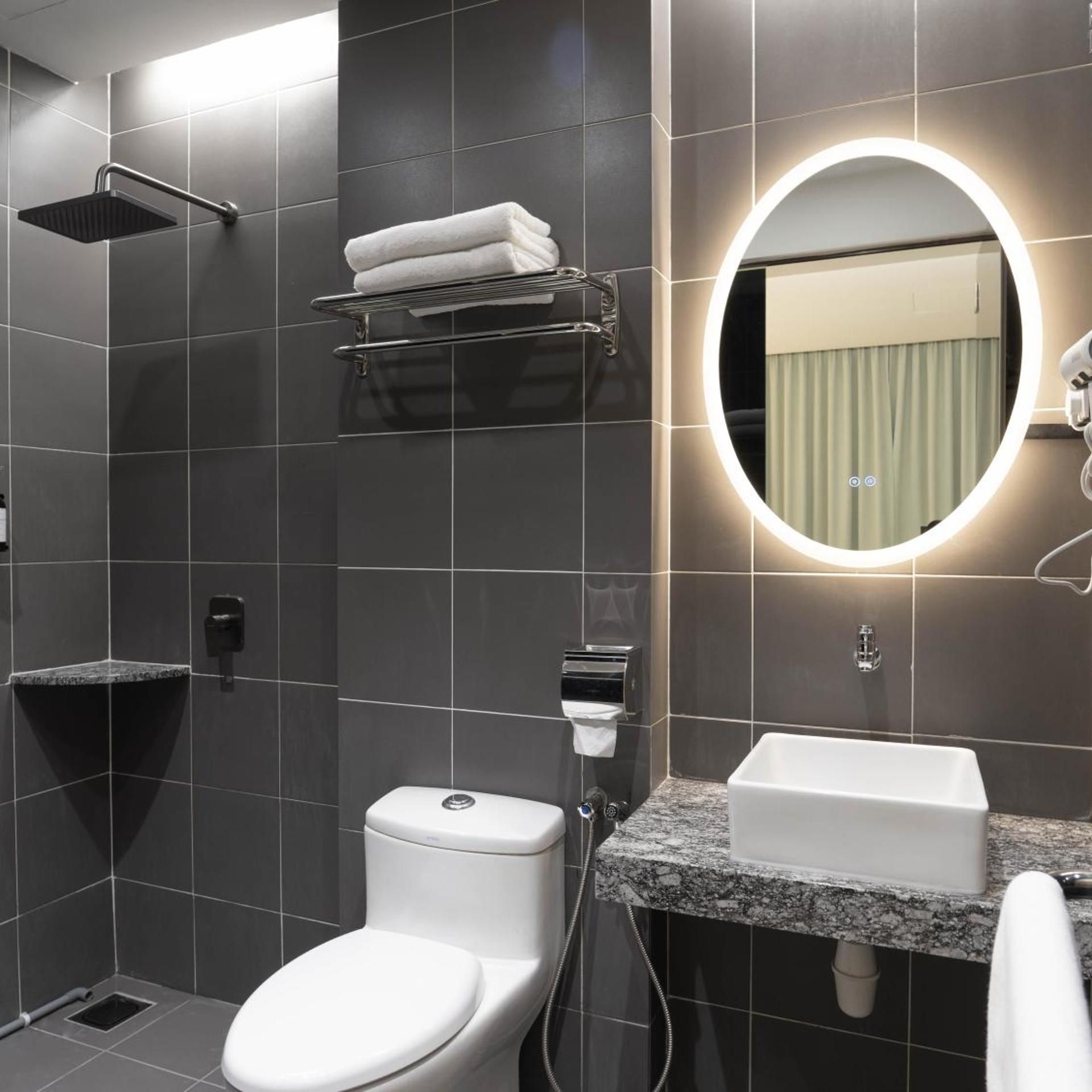 A modern bathroom with a toilet, sink, and shower.