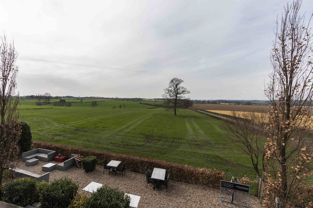 Vista de un campo cubierto de césped con una zona de estar y un letrero.