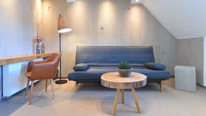 Un salon moderne avec un canapé bleu, une table basse en bois et un lampadaire.