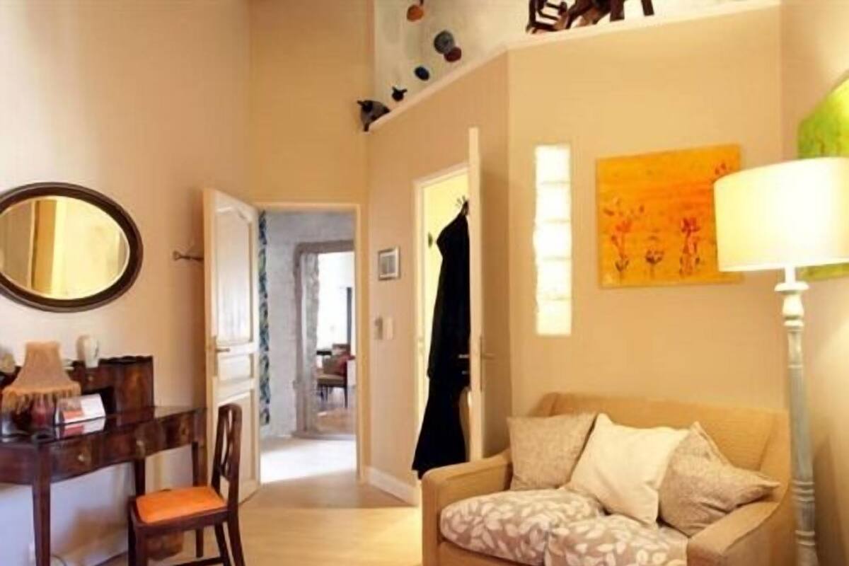 A cozy living room with a sofa, a chair, a lamp, and a painting on the wall.