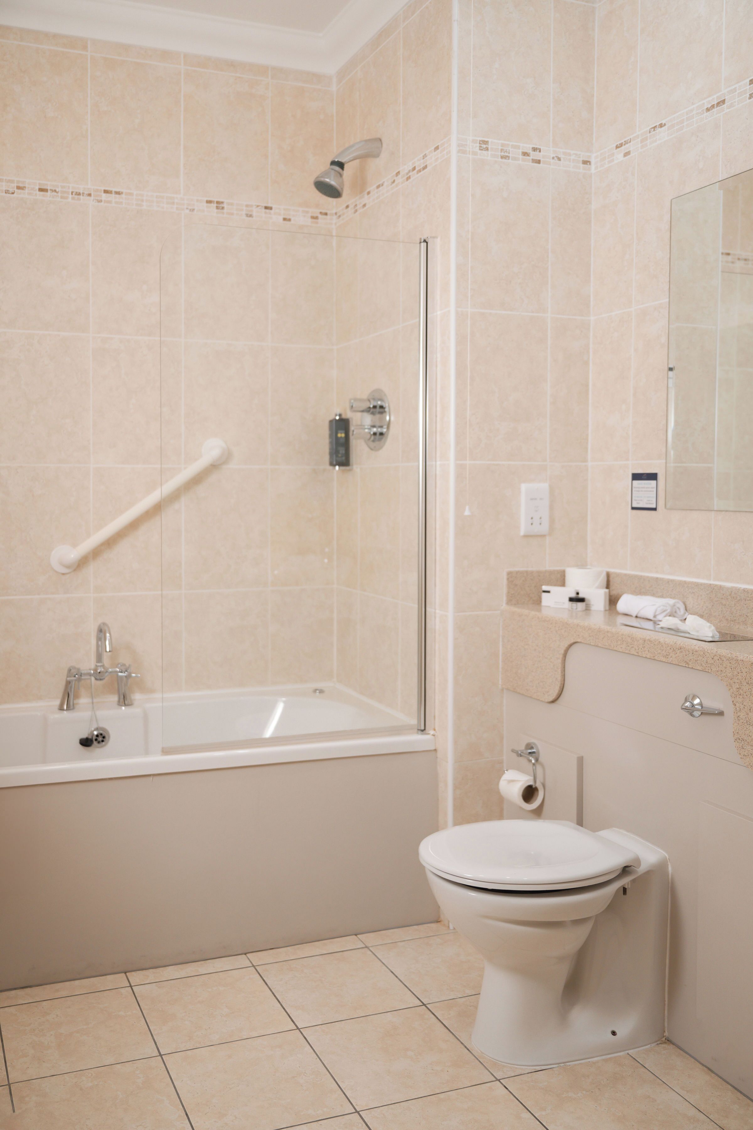 A bathroom with a bathtub, toilet, and a glass shower enclosure.