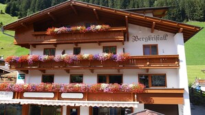 A traditional wooden building with balconies adorned with colorful flowers, labeled "Bergkirche."