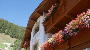 A traditional wooden building with balconies adorned with colorful flowers.