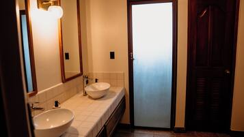 Un baño con dos lavabos, un espejo y una puerta.