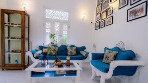 A living room with two blue sofas, a white coffee table, and a wooden cabinet. - Fort Heaven (Galle)