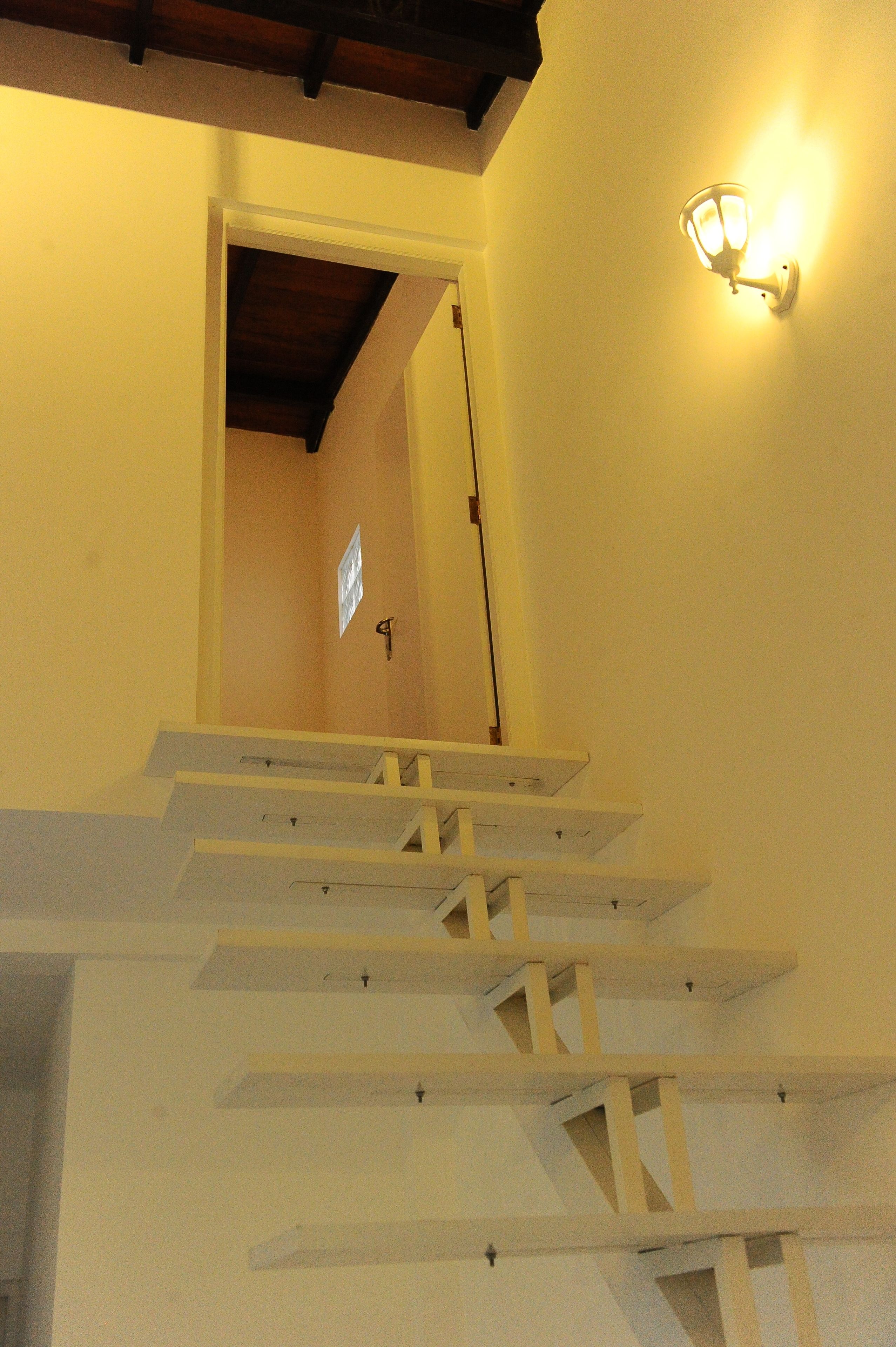 A staircase with white steps and a wooden beam ceiling.