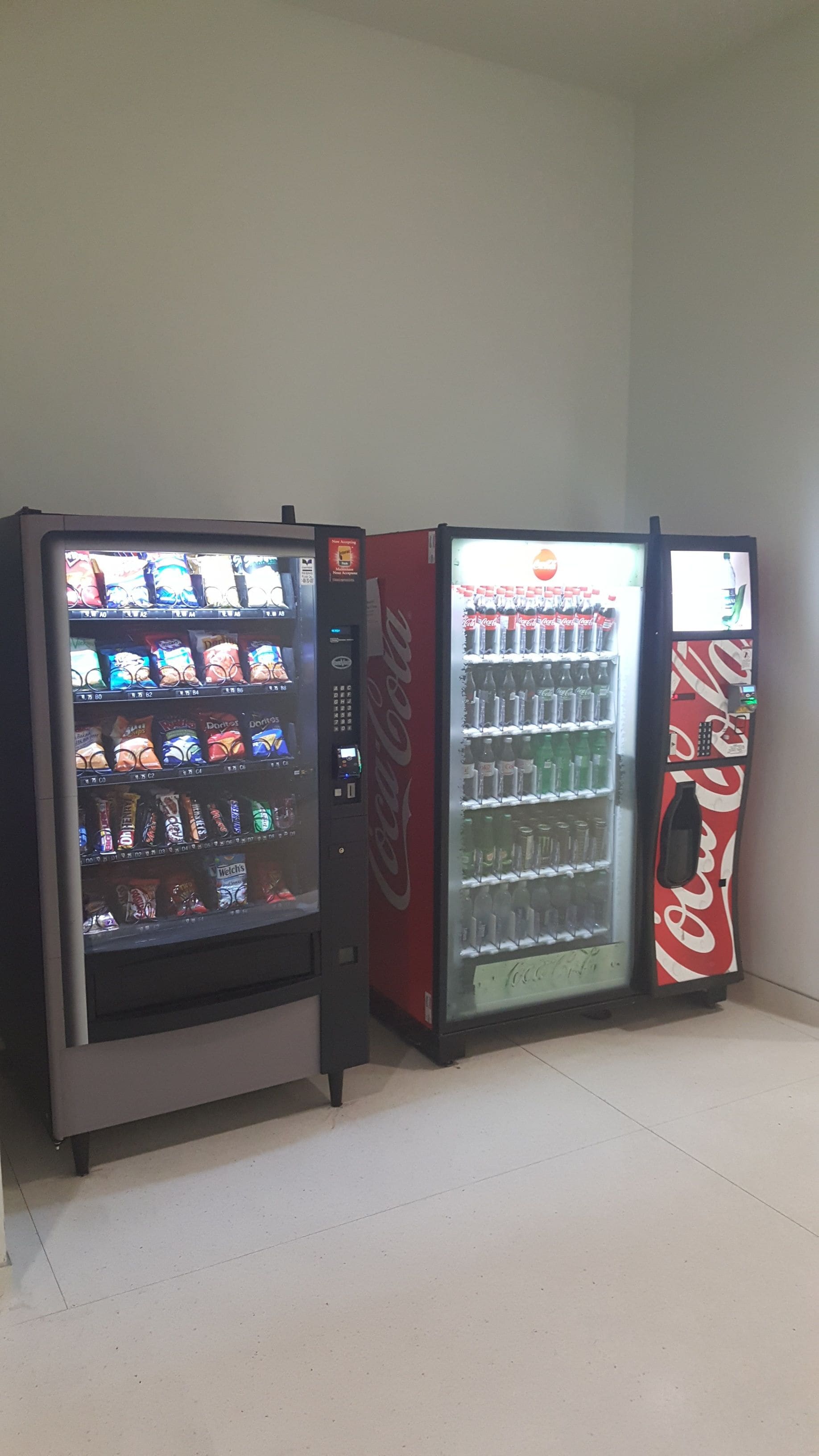 Three vending machines with snacks and beverages.