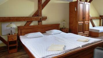 Un dormitorio con una cama de madera, dos mesitas de noche, un armario y un equipo de aire acondicionado.