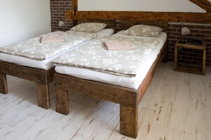 Una cama doble con ropa de cama floral, un cabecero de madera y una mesita de noche con lámpara.