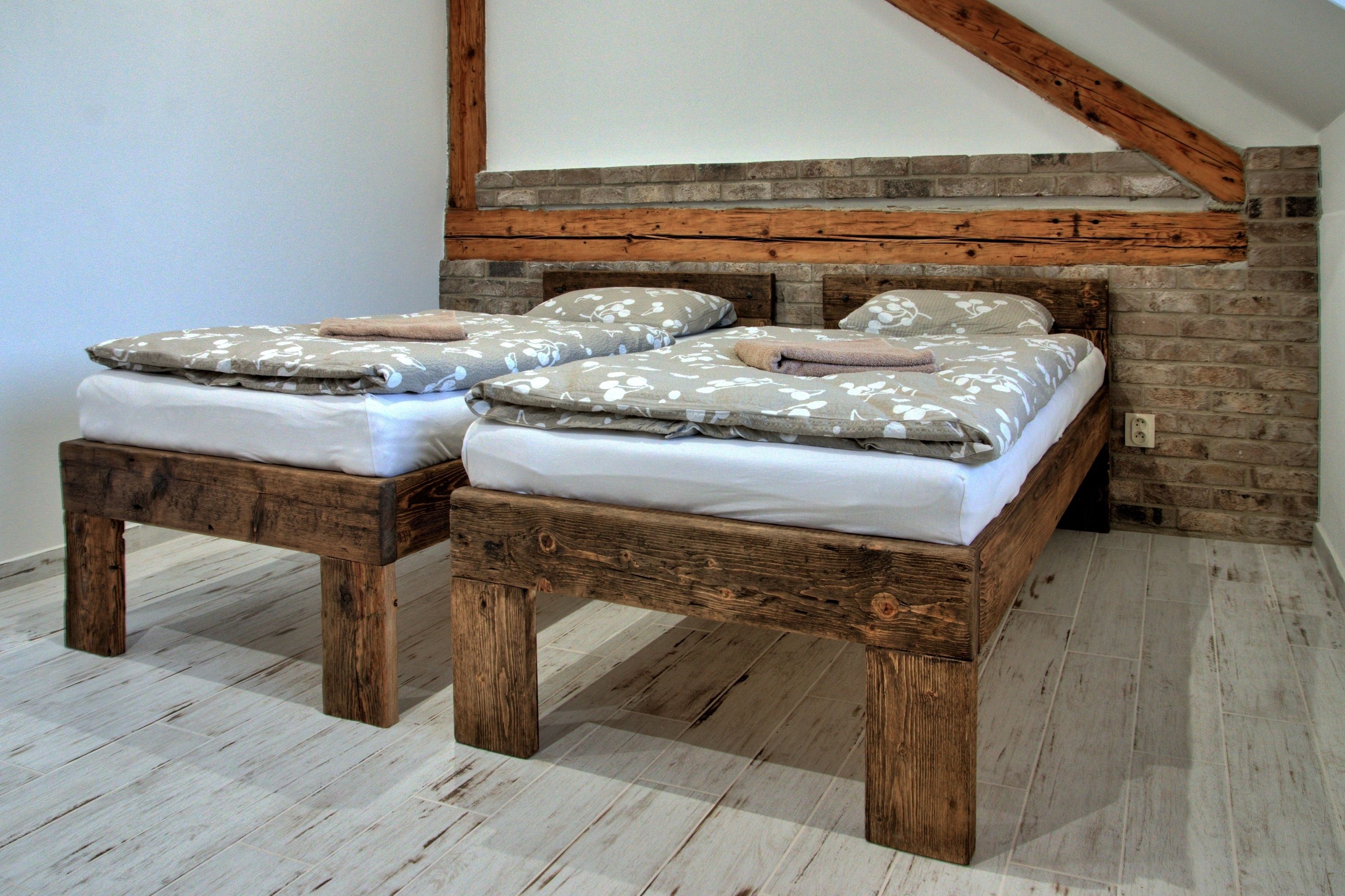Un dormitorio rústico con cama estilo loft y dos mesitas de noche de madera.