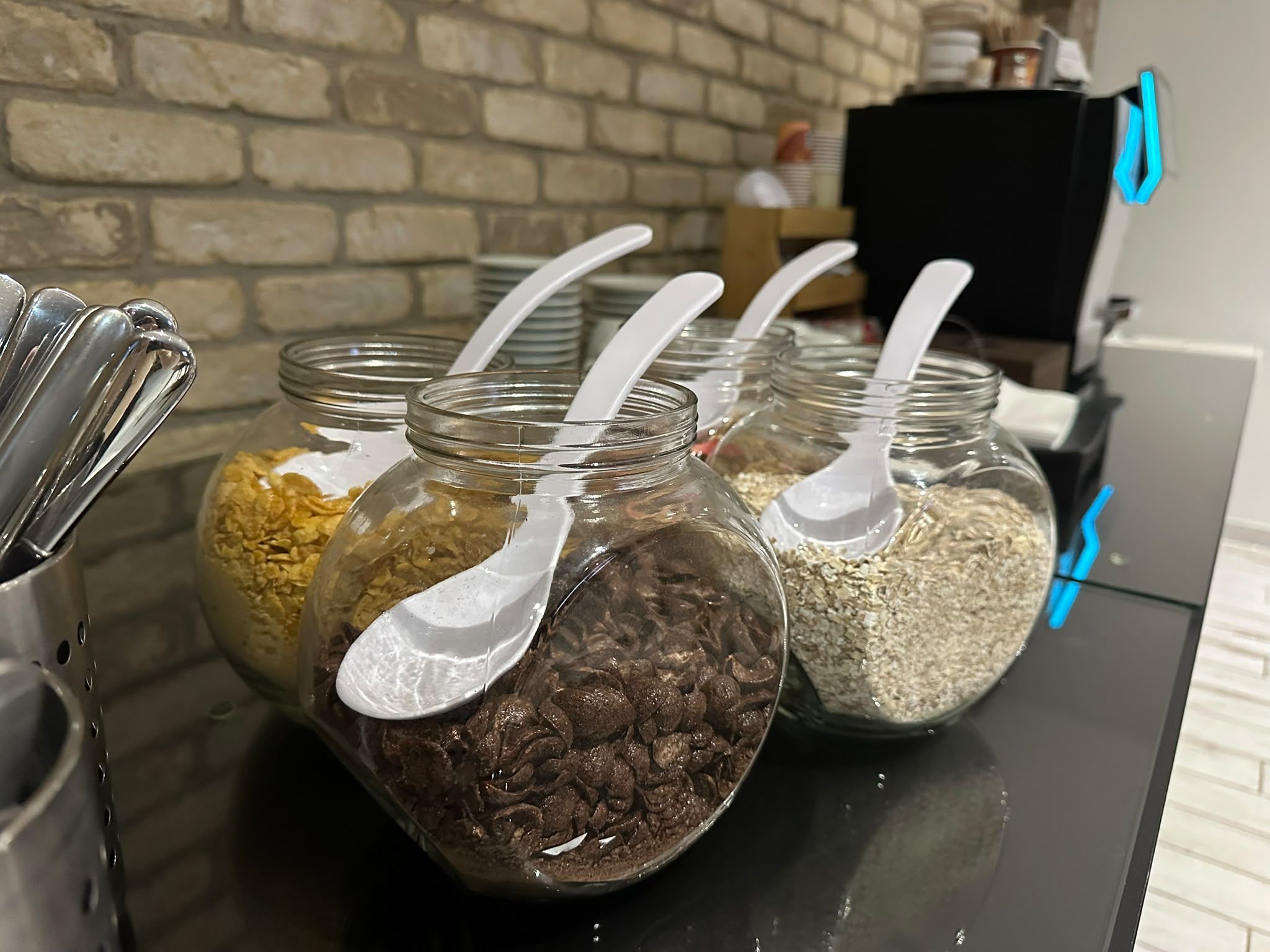 Glazen potten met lepels op een aanrecht, gevuld met diverse soorten eten.