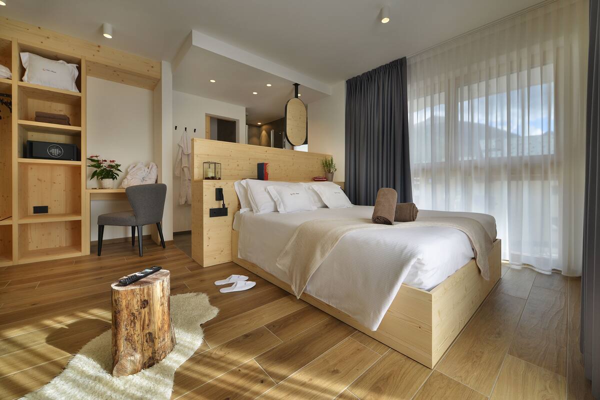 A modern bedroom with a wooden bed, a desk, and a chair.