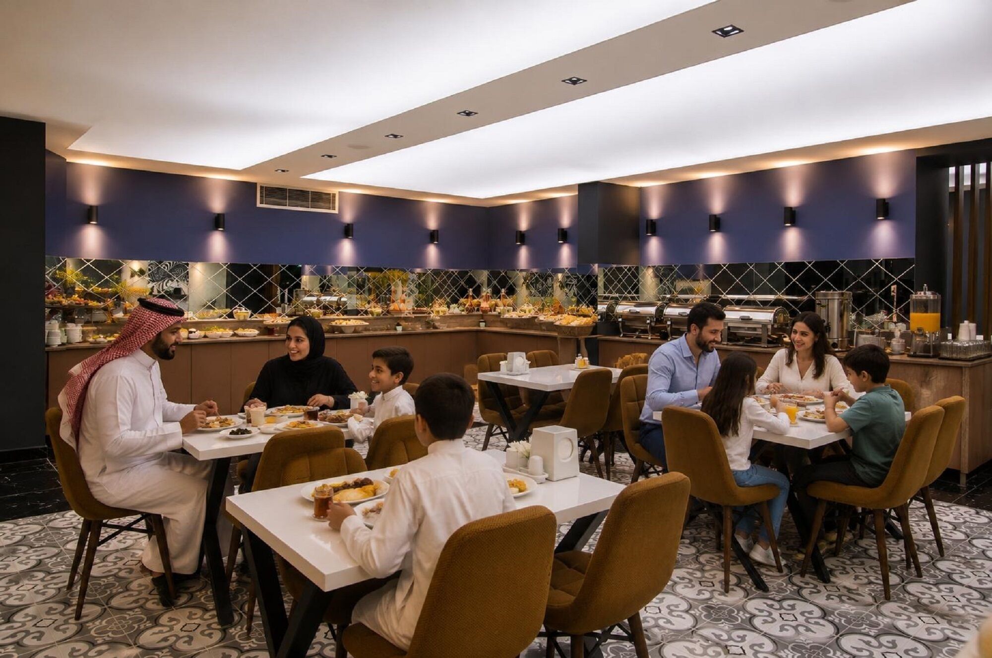 A dining area with tables and chairs, a buffet with food and drinks, and a modern ceiling design.