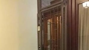 A staircase leading to a door with a metal grille, a patterned carpet, and a light fixture above the door. - Casa Rosy (Rome)