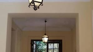 A hallway with a hanging lantern and a door leading outside. - Casa Rosy (Rome)