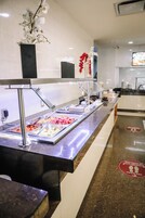 A buffet area with various food options and a decorative plant.