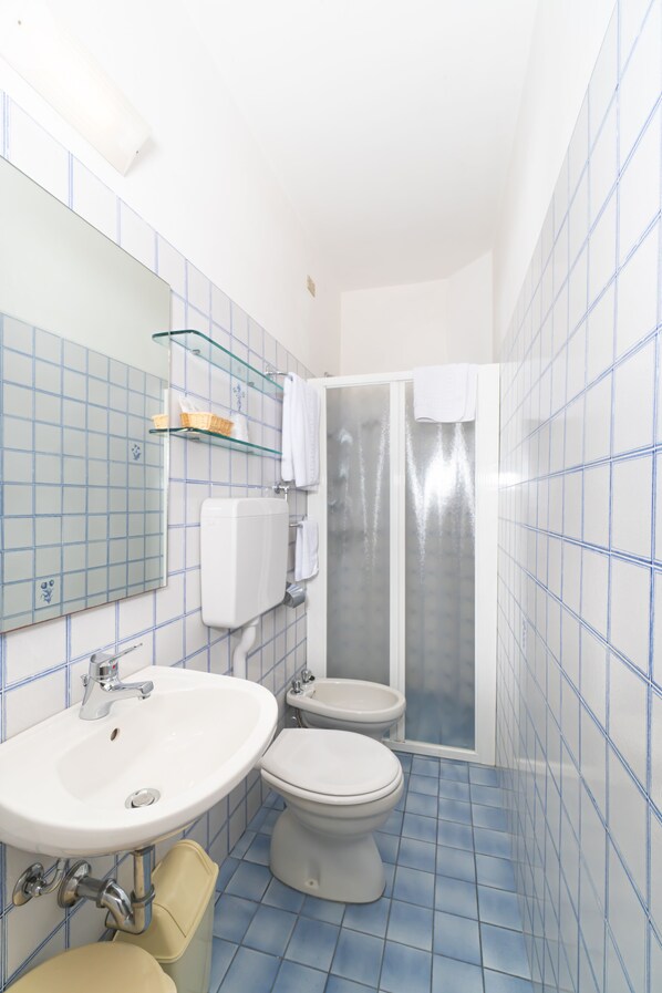 A bathroom with a sink, toilet, and shower.