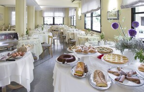 A dining area with multiple tables set for breakfast, featuring a variety of pastries and desserts. - Hotel Sampaoli (Bellaria-Igea Marina)