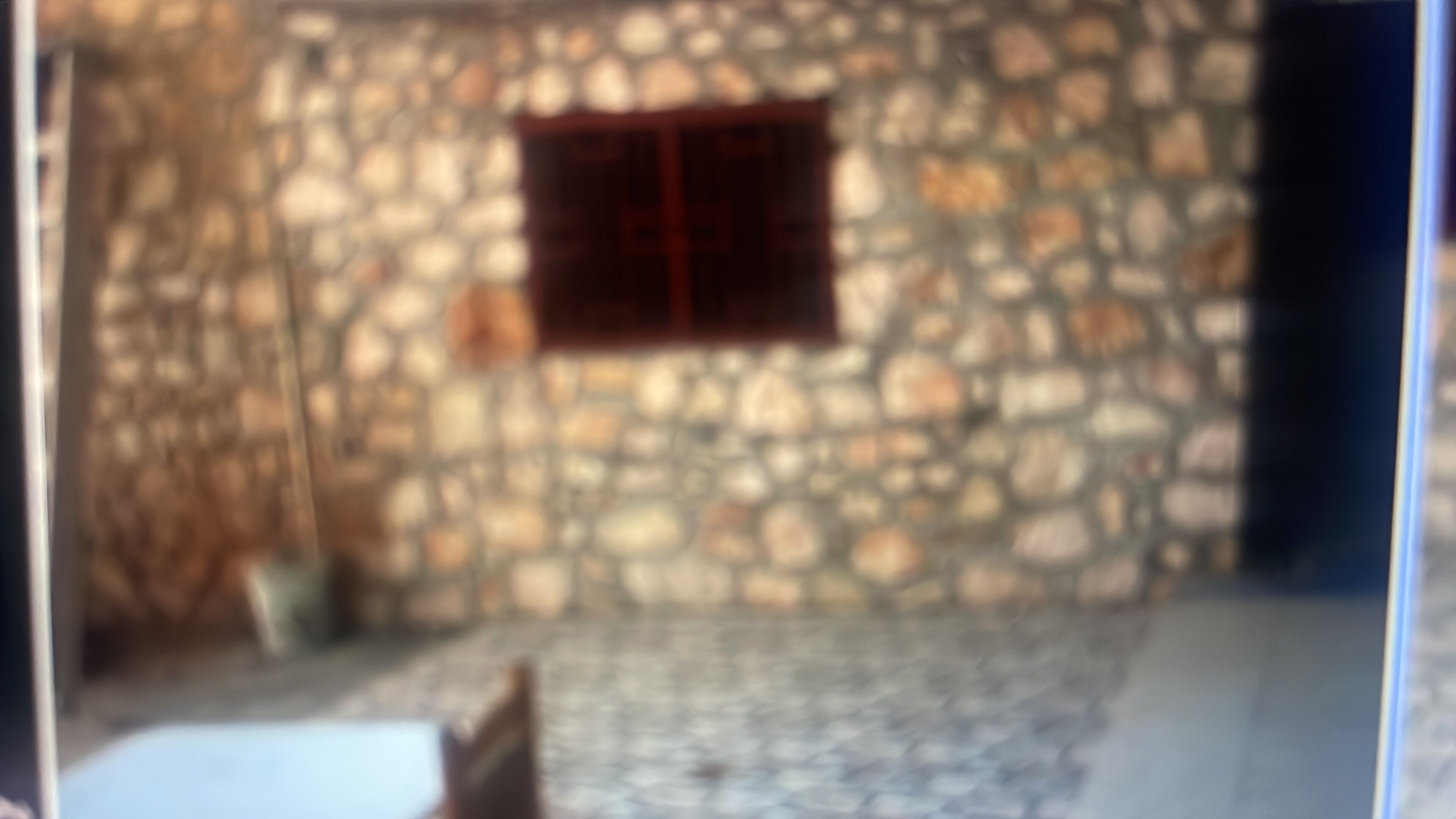 A stone building with a window and a door.