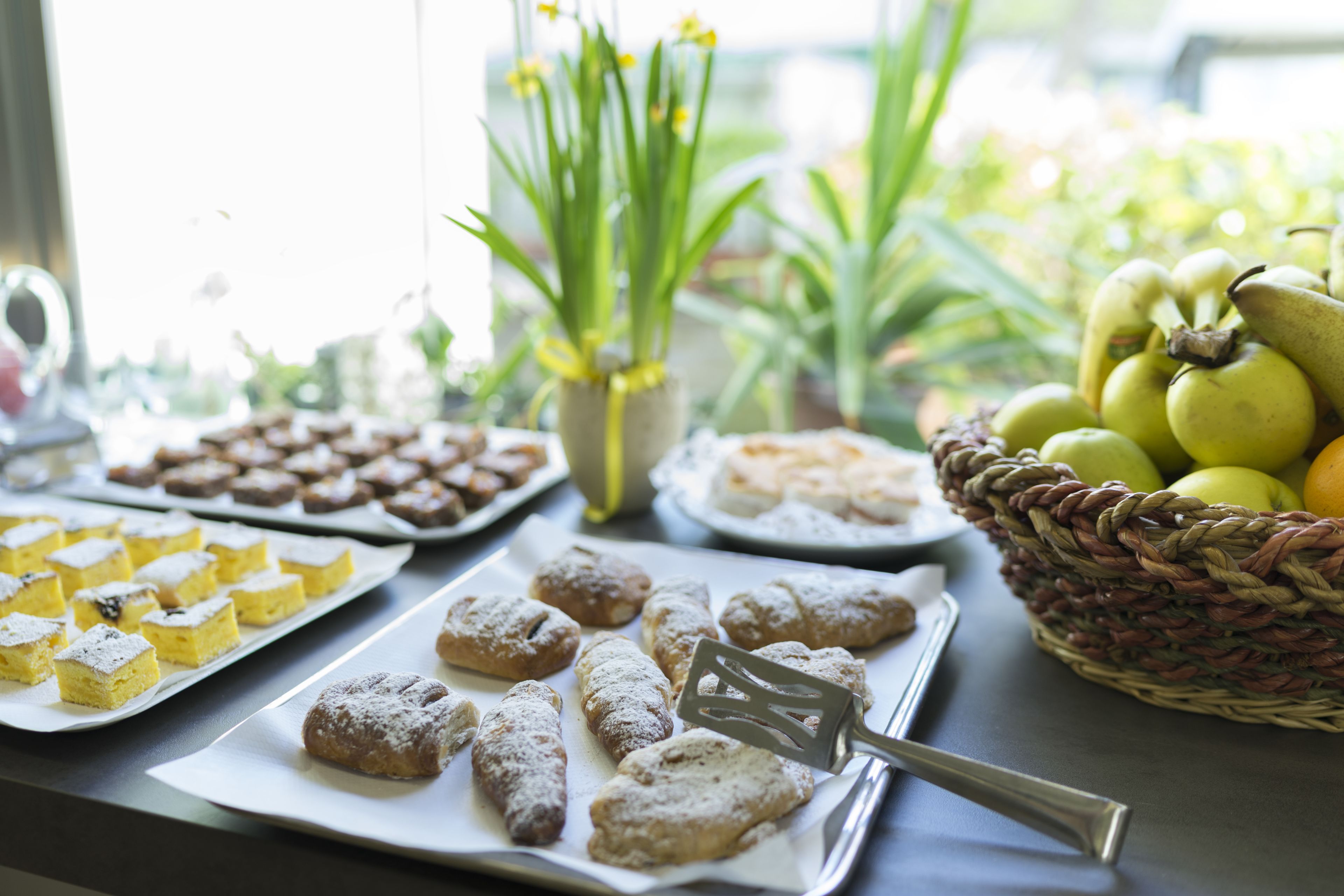 A buffet table with various desserts and fruits.
