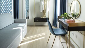 Ein modernes Schlafzimmer mit einem Bett, einem Schminktisch mit Spiegel, einem Schreibtisch und einem Stuhl.