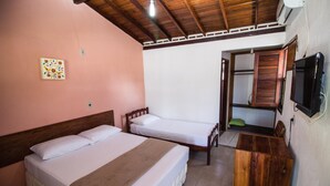 Una habitación con dos camas, un armario de madera y una televisión.