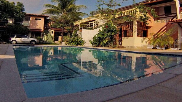 Una piscina con agua cristalina, rodeada por una solana con baldosas.