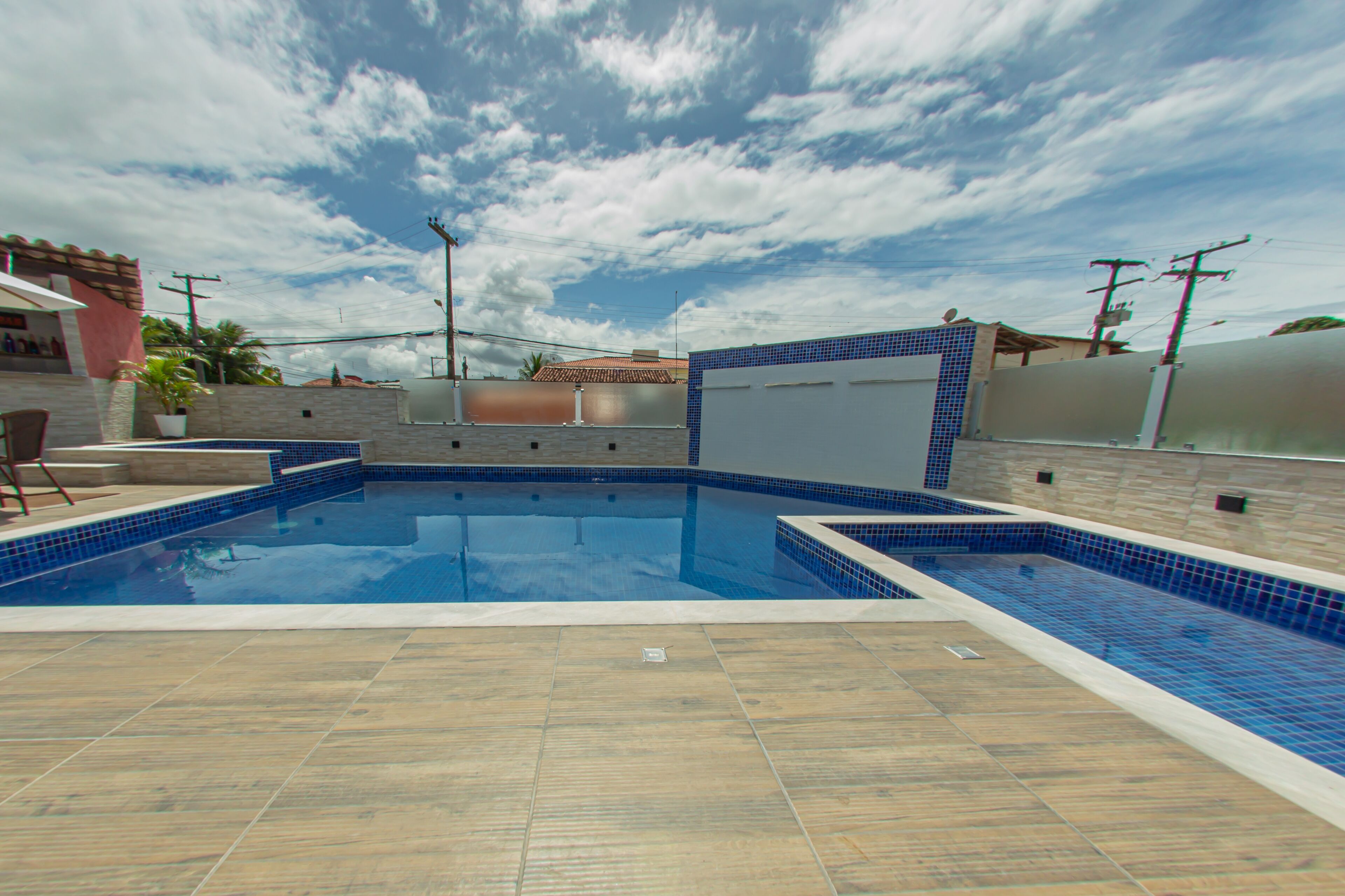 A swimming pool with blue tiles and a tiled deck area.