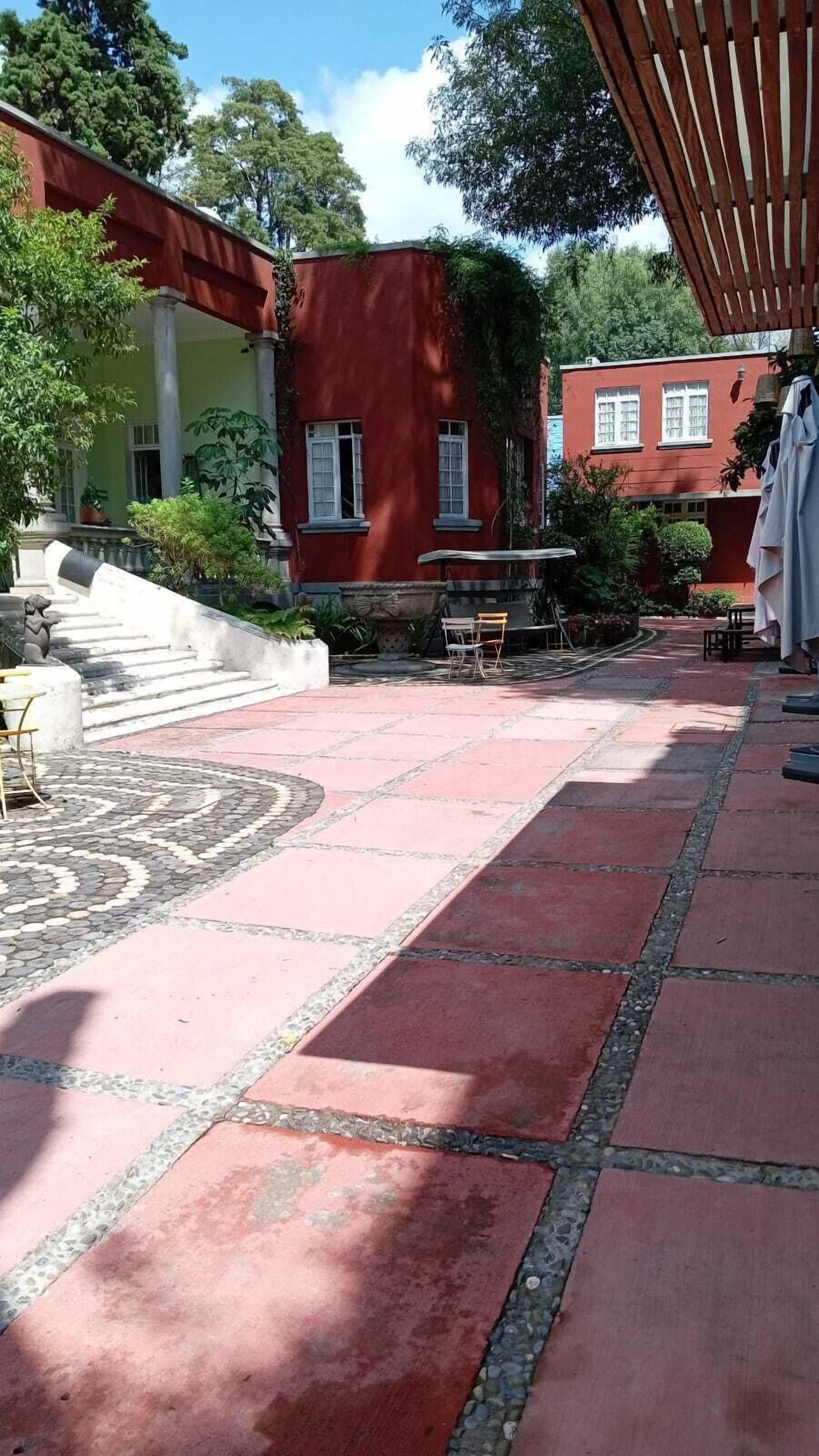 Une cour avec un sol décoré, des sièges extérieurs et un espace abrité.