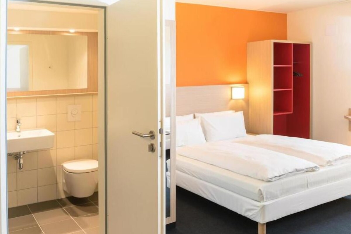 Una camera d'albergo con bagno, letto e armadio.