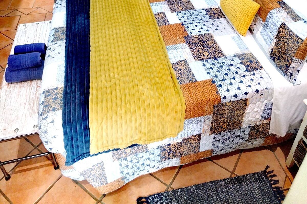 Une chambre à coucher comprenant un lit, une table de chevet, une lampe et deux œuvres d’art murales.