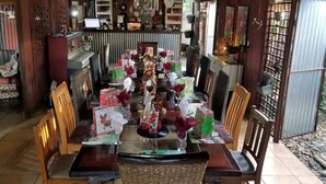 Un comedor con una mesa de madera dispuesta para una comida, rodeado de sillas.