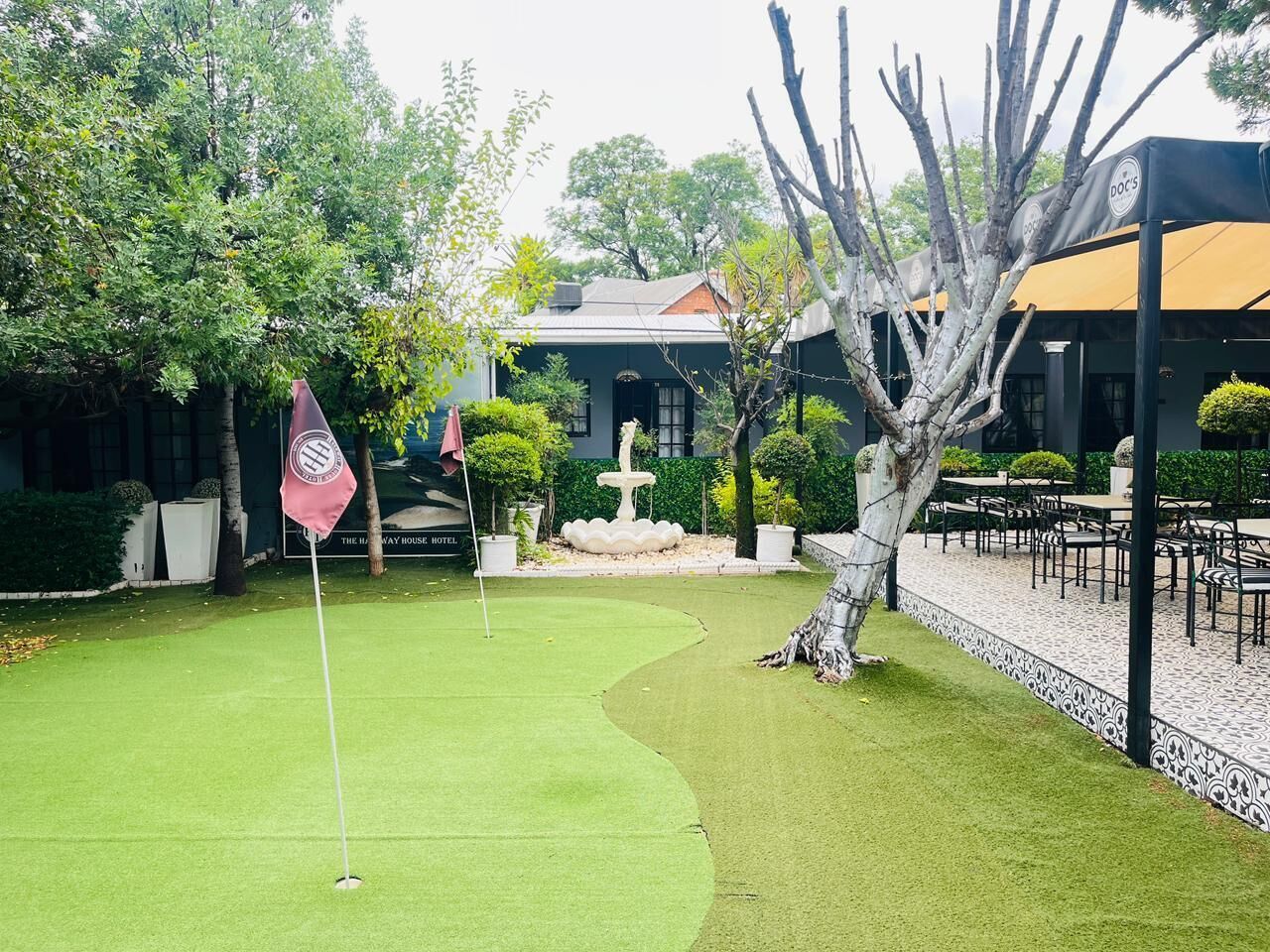 Un campo de golf con un putting green, una bandera y una fuente.