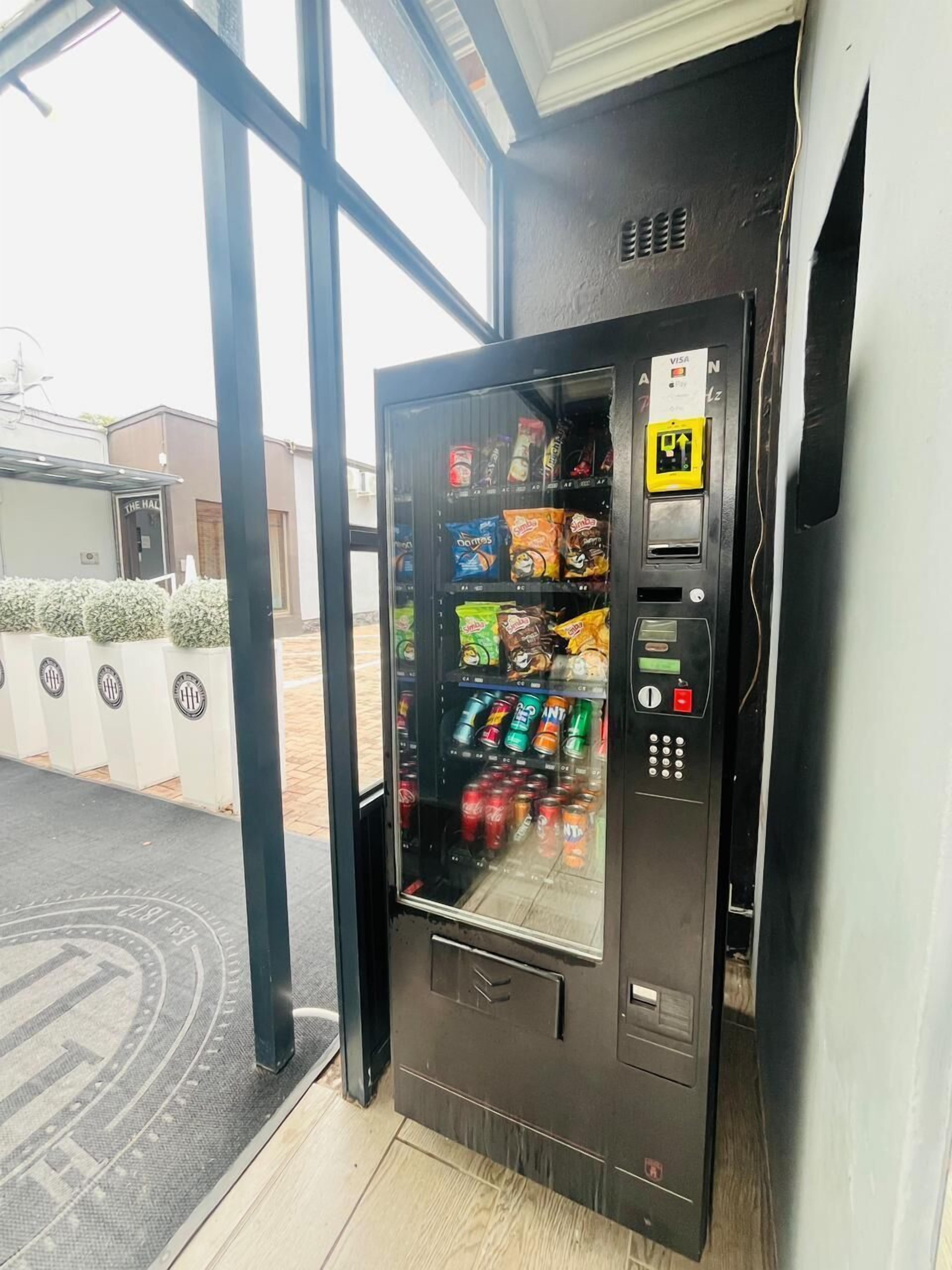 A vending machine with snacks and drinks, a payment card slot, and a keypad.