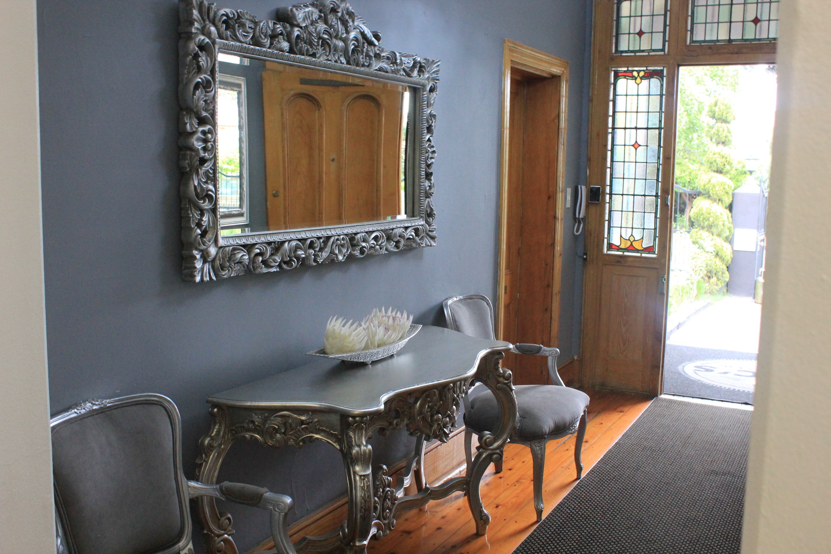 A dining area with a table, chairs, and a decorative mirror.