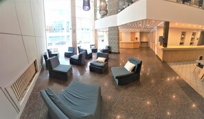 A spacious lobby with multiple seating areas, a reception desk, and a view of the outside. - America Hotel (Mar del Plata)