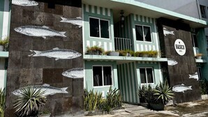 A building with a sign reading "BASICO HOTEL" and fish decorations on the facade.