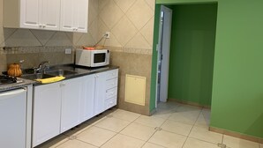 A kitchen with white cabinets, a microwave, and a sink. - Apart Chalten (El Calafate)