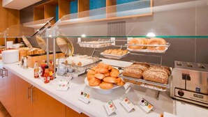 A buffet with various food items, including pastries, bread, and condiments. - Lexington Vacations Kiss by Stark Hosp (Orlando)