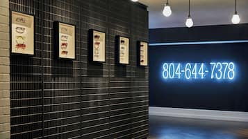 A wall with framed eyewear displays and a neon sign with a phone number.