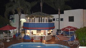 A pool area with lounge chairs, umbrellas, and a bar area with seating. - Hotel Mediterraneo (Playas de Rosarito)